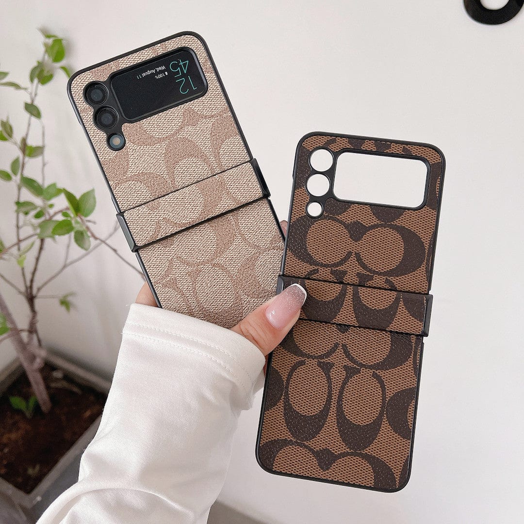 Coach Z Flip/Z Fold Samsungin puhelinkotelo sormihihnalla